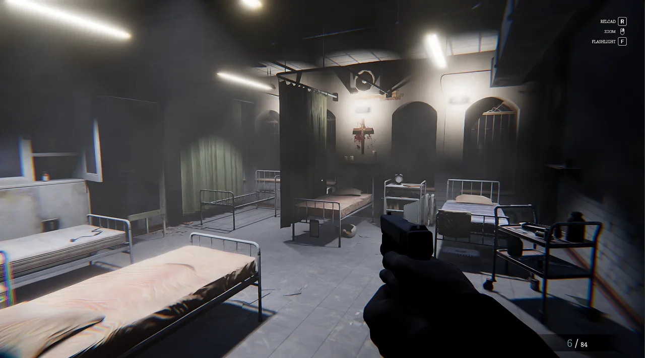 A ward with iron beds and a bloodied crucifix on the wall